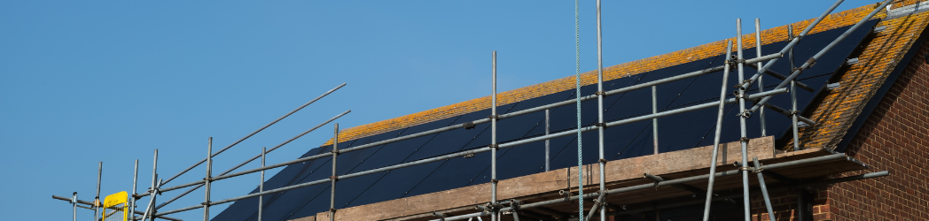 Scaffolding being erected on a residential home for solar panel installation, illustrating a project that may require planning permission.